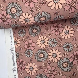 Katoenen stof met bloemenmotief in roze, beige en blauw tinten op oudroze ondergrond