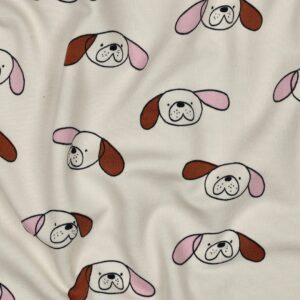 Crèmekleurige stof met herhalend patroon van getekende hondenkoppen met roze en bruine oren