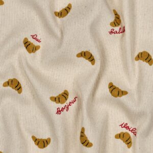 Crèmekleurige ribstof met geborduurd croissant patroon en Franse groeten zoals Bonjour, Salut en Oui